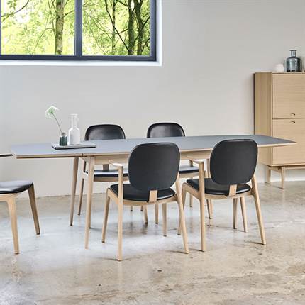 Miljøbillede fra PBJ Designhouse af et Navis spisebord med laminat bordplade og fem spiseborddstole