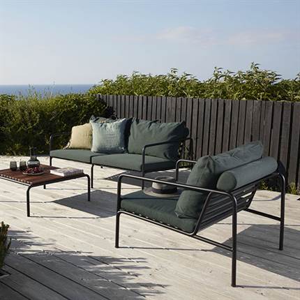 Terrasse med loungemøbler i stål med grønne hynder.