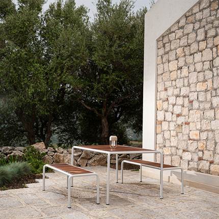 Terrasse med et havesæt i træ bestående af et havebord og to havebænke