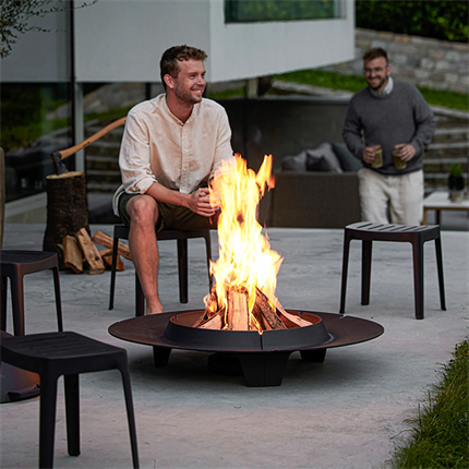 Miljøbillede af to mænd der sidder og hygger omkring et bål i det store Ember bålfad fra Cane-Line