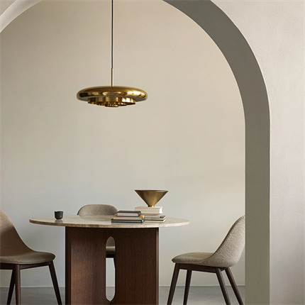 Miljøbillede af Resonant pendel i messing fra Audo Copenhagen hænger over et spisebord.